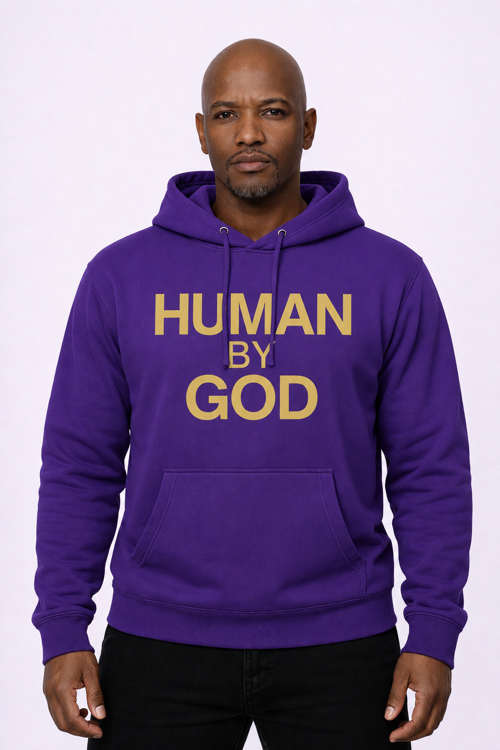 Watched Over. Built Different. — Front view model wearing purple hoodie with gold HUMAN BY GOD logo